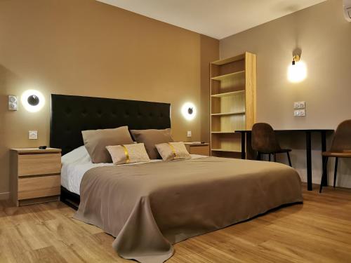 a bedroom with a large bed and a desk at Appart Hotel Spa Perpignan in Perpignan