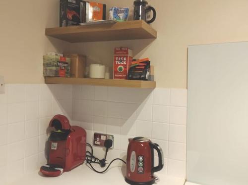 a kitchen counter with a red appliance plugged into a outlet at 2 Bed Flat Near Station with Parking&Comgarden in Sutton