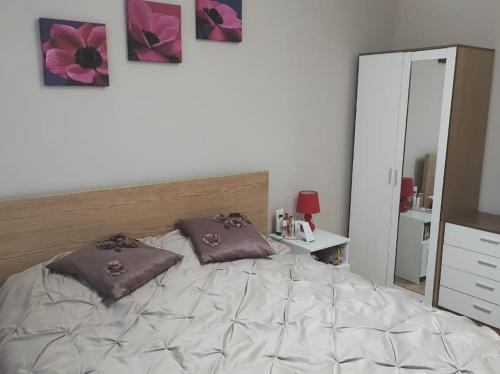a bedroom with a bed with two pillows on it at 2 Bed Flat Near Station with Parking&Comgarden in Sutton