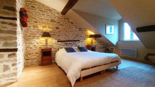 um quarto com uma cama grande numa parede de pedra em La Vallée Verte em Grandchamp