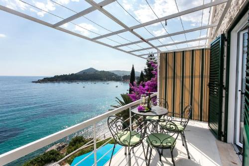 een balkon met een tafel en stoelen en de oceaan bij Apartments Villa Mirjana in Mlini