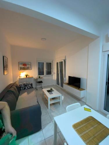 a living room with a couch and a table at Sunny Peraia Apartment in Perea