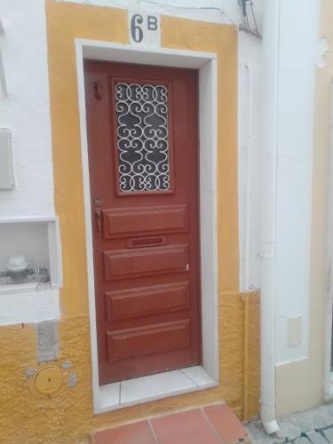 a red door on the side of a building at Casa da Romeira in Elvas