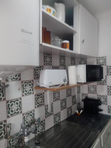 a kitchen with a sink and a microwave at Casa da Romeira in Elvas