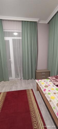 a bedroom with a bed and a large window at Olesya Guesthouse in Mtsvane Kontskhi