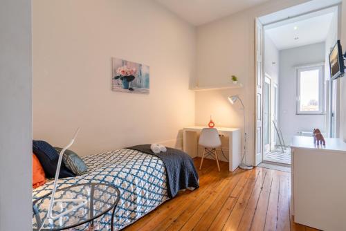 a bedroom with a bed and a desk and a sink at Sweet Bright Flats - City Center in Porto