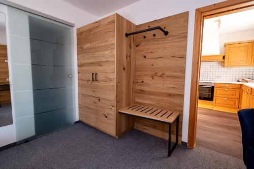 einen Holzschrank mit einer Bank in einem Zimmer in der Unterkunft SL Hotel in Bad Wiessee