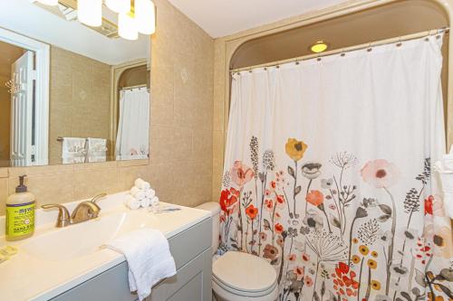 a bathroom with a sink and a toilet and a shower curtain at Oceanfront 1 bedroom King suite- Ocean Forest Plaza 1911 in Myrtle Beach