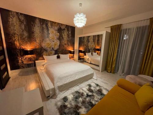 ein Schlafzimmer mit einem Bett, einem Sofa und einem Kronleuchter in der Unterkunft House of Art in Braşov
