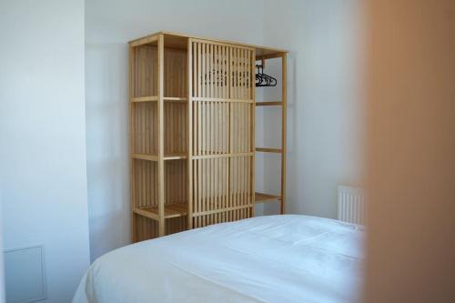 ein Schlafzimmer mit einem Bett und einem Bücherregal in der Unterkunft Douceur en Baie, maison neuve - 4 à 6 pers in Saint-Valery-sur-Somme