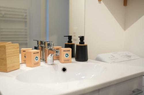 eine Badezimmertheke mit Markenprodukten auf einem Waschbecken in der Unterkunft Douceur en Baie, maison neuve - 4 à 6 pers in Saint-Valery-sur-Somme