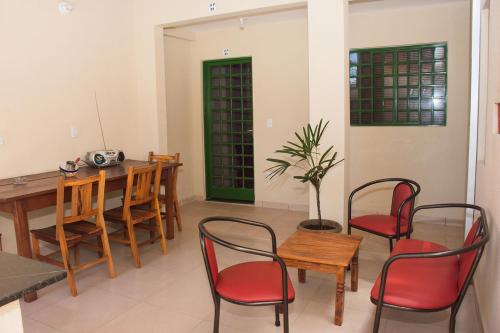 a dining room with a table and red chairs at Otimo apto com lazer e Wi-Fi em Campo Grande MS in Campo Grande