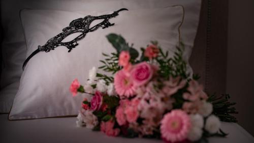 a bouquet of pink flowers on a white pillow at Apartament Sensual SAUNA&JACUZZI Poznań Stare Miasto in Poznań