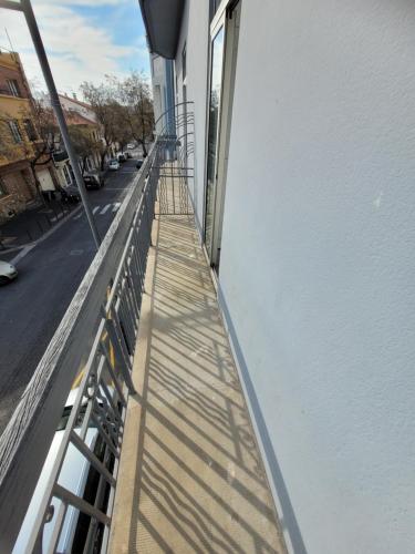 a balcony of a building with its shadows on the side at Hôtel Aragon - Centre ville gare in Perpignan