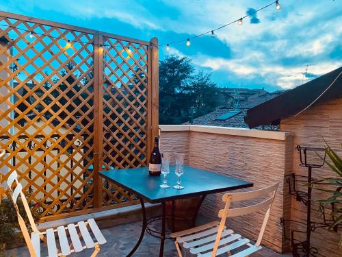 a patio with a table and chairs and a fence at Lo chalet di Giulia - Romantic terrace in Bologna
