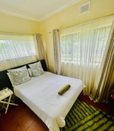 a bed in a room with a large window at 25 Swallow Yellowood in Durban