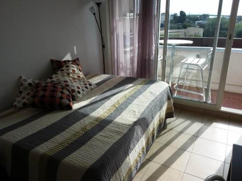 - une chambre avec un lit et un balcon dans l'établissement Capnaturiste8, au Cap d'Agde