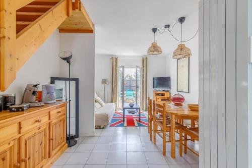 une cuisine et une salle à manger avec une table et des chaises dans l'établissement LA ROSE DE L OCEAN, à Saint-Hilaire-de-Riez