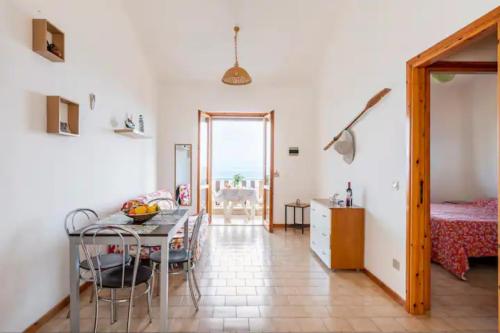 a living room with a table and a bedroom at Sant'Alessio Village in SantʼAlessio Siculo