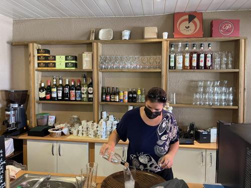 Un homme se tient au comptoir dans un bar dans l'établissement Restaurant - Chambres d'Hôtes Terra Bella Lecci, à Porto-Vecchio