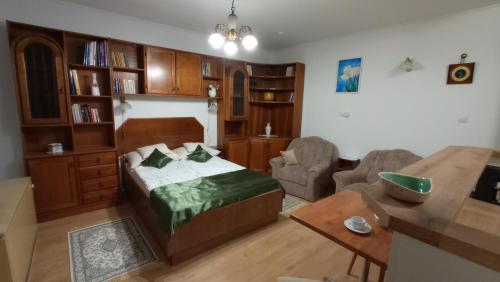 ein Schlafzimmer mit einem Bett und ein Wohnzimmer in der Unterkunft Londira Apartman Hévíz in Hévíz