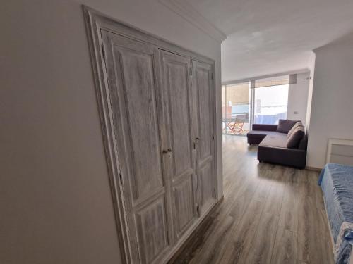 una sala de estar con una gran puerta de madera y un sofá en Apartamento Zefiro, en San Miguel de Abona