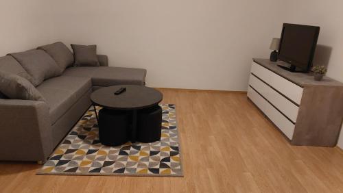 un salon avec un canapé et une télévision dans l'établissement Apartman B&Đ Split, à Split