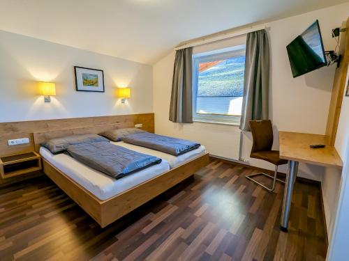 sypialnia z 2 łóżkami i oknem w obiekcie Appartement Haus Talblick w Kaprunie