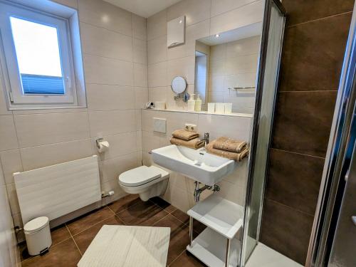 y baño con aseo, lavabo y ducha. en Appartement Haus Talblick, en Kaprun