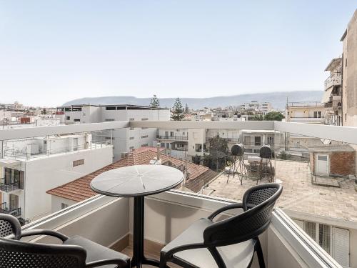 a balcony with chairs and a table and a view at M City Hotel in Chania Town