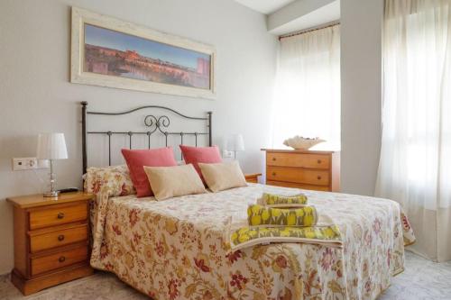 1 dormitorio con 1 cama grande con almohadas rojas y amarillas en Piso Céntrico Plaza San Miguel, en Córdoba