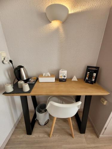 a desk with a chair and a light on a wall at Hôtel Aragon - Centre ville gare in Perpignan