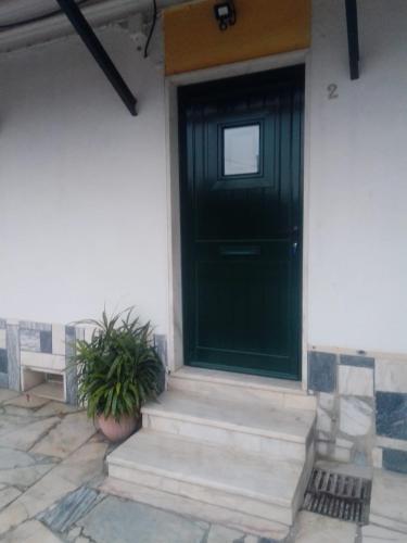 a black door on a white house with a potted plant at Casas da Saibreira - nº2 in Elvas