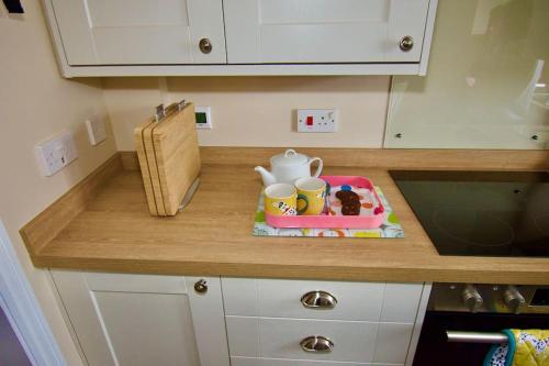 a kitchen counter with a tray with a tea set on it at Cottage in Framlingham in Framlingham