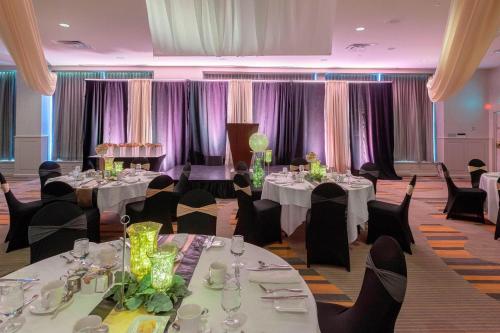 a banquet room with tables and chairs and purple curtains at Delta Hotels by Marriott Saint John in Saint John