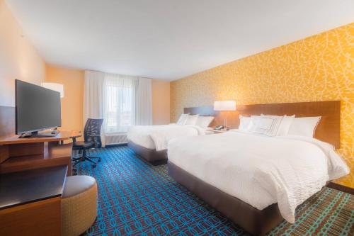 a hotel room with two beds and a flat screen tv at Fairfield Inn & Suites by Marriott Gaylord in Gaylord