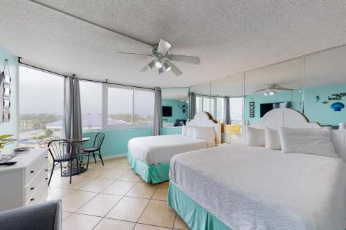 パナマ・シティ・ビーチにあるThe Top of the Gulf #612のベッド2台とテーブルが備わるホテルルームです。
