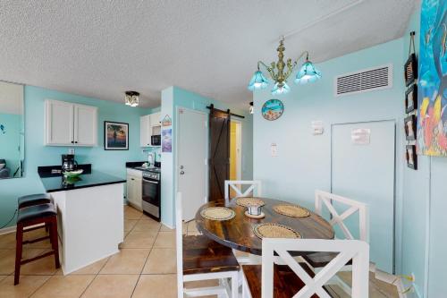 a kitchen and dining room with a table and chairs at The Top of the Gulf #612 in Panama City Beach
