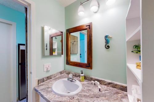 a bathroom with a sink and two mirrors at The Top of the Gulf #612 in Panama City Beach