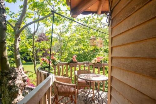 un patio con mesa y sillas en un porche en Lake Como Dream Tree House, en Como