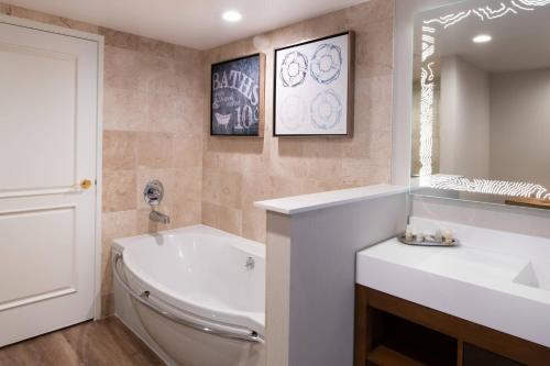 a bathroom with a tub and a toilet and a sink at Renaissance Newport Beach Hotel in Newport Beach