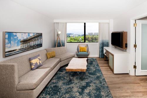 a living room with a couch and a tv at Renaissance Newport Beach Hotel in Newport Beach
