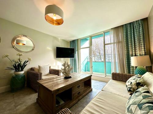 a living room with a couch and a table at Stunning 2 bedroom Apartment inc Free Parking - 1 Minute walk to Poole Quay - Great Location - Free Parking - Fast WiFi - Smart TV - Newly decorated - sleeps up to 4 - Close to Poole & Bournemouth & Sandbanks in Poole