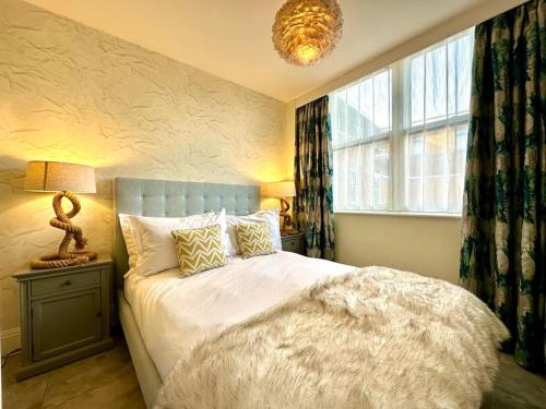 a bedroom with a large bed and a window at Stunning 2 bedroom Apartment inc Free Parking - 1 Minute walk to Poole Quay - Great Location - Free Parking - Fast WiFi - Smart TV - Newly decorated - sleeps up to 4 - Close to Poole & Bournemouth & Sandbanks in Poole