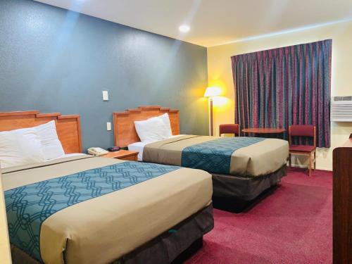 um quarto de hotel com duas camas e uma janela em Rodeway Inn Winslow I-40 em Winslow