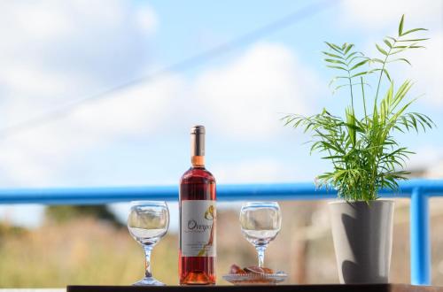 Una botella de vino y dos copas en una mesa. en Verano Apartments, en Kalymnos