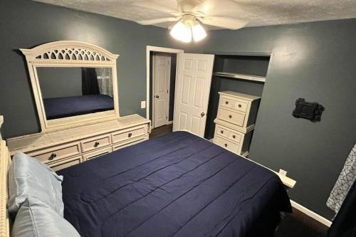 a bedroom with a blue bed and a mirror at Quiet Getaway in La Follette