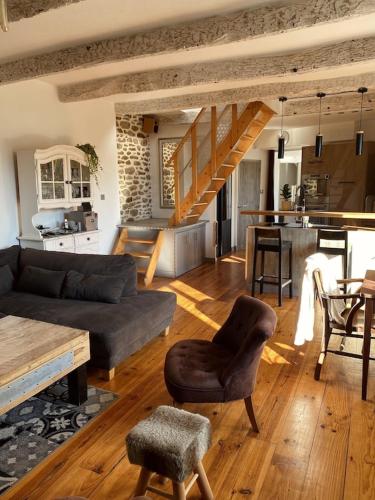 un salon avec un canapé et une table et une cuisine dans l'établissement La maison d’Aurélie, à Pleudihen