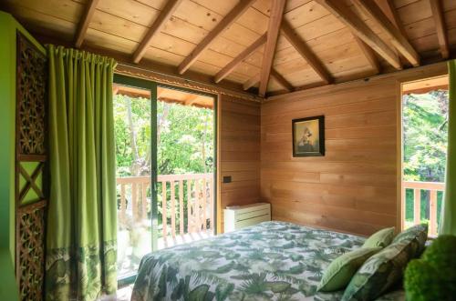 a bedroom with a bed and a large window at Lake Como Dream Tree House in Como