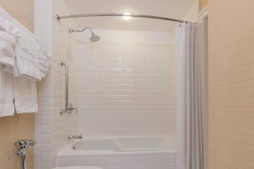 a bathroom with a shower and a white tub at The Raphael Hotel, Autograph Collection in Kansas City